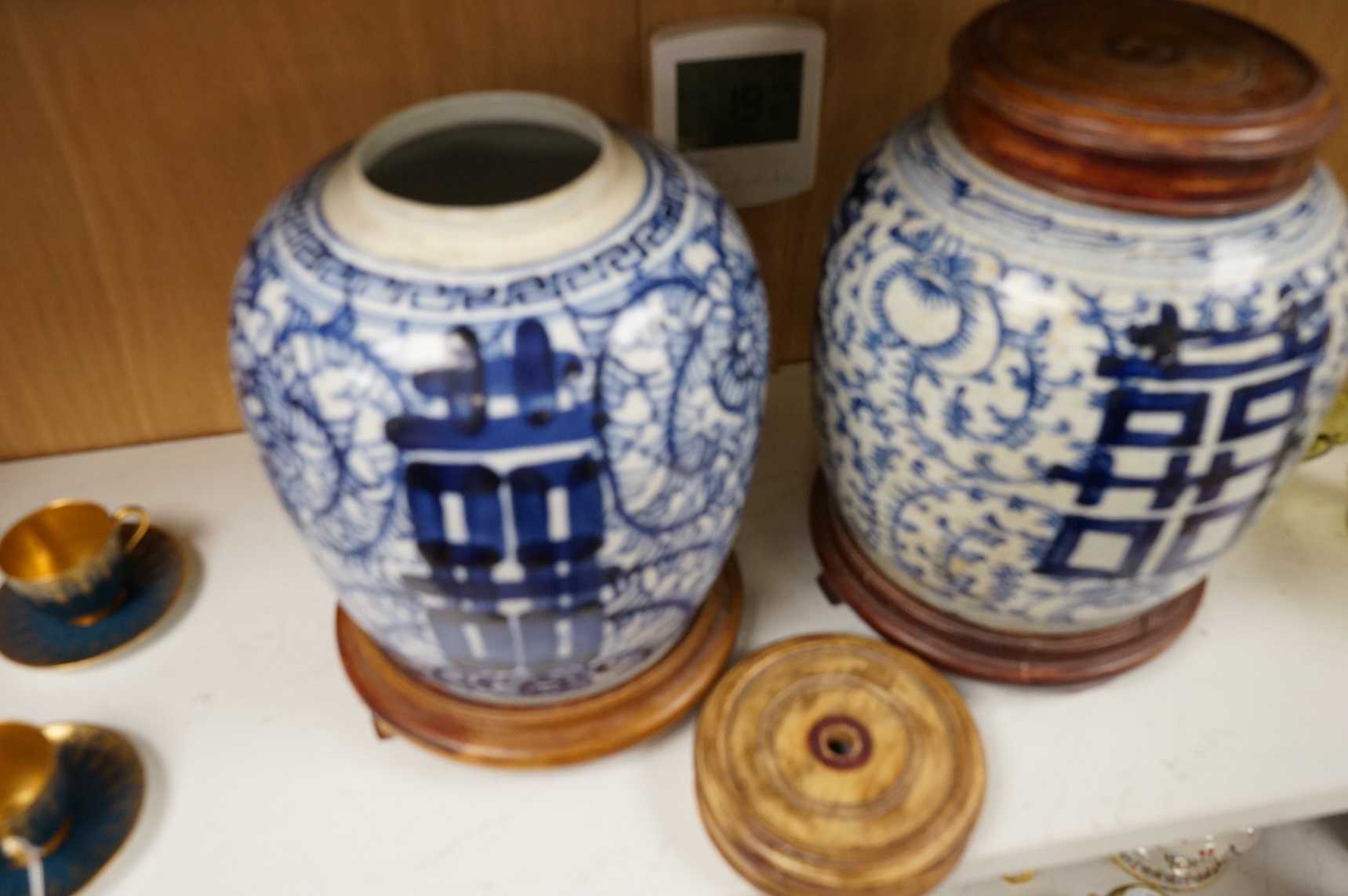 Two Chinese blue and white jars with hardwood stands and covers, 28cm high